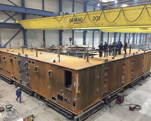 Der Starttisch für die Ariane 6 bei der Inspektion im Werk Ende November 2017 (links, ©ESA) und der Schwertransport der ersten Mastteile zum Verschiffen nach Kourou (rechts, ©MT Aerospace AG).